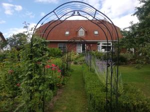 a garden with a greenhouse in front of a house at Ferienwohnung 2 Schulze in Neustrelitz