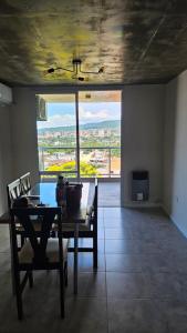 a dining room with a table and chairs and a large window at El Mirador in San Salvador de Jujuy