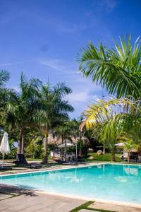 una piscina con palmeras en un complejo en Apartamento en Playa Coconut @drvacationsrental en Puerto Palenque
