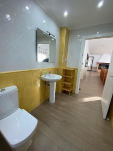 a bathroom with a toilet and a sink and a mirror at Casa Rural El Pino in Albacete
