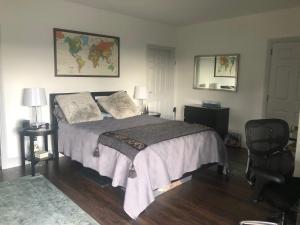 1 dormitorio con cama, silla y espejo en The Stone Cottage en Glengarriff