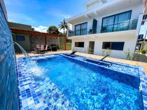a large swimming pool in front of a house at Home Aguas da barra Ilhabela in Ilhabela