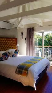 a bedroom with a large bed and a large window at Onrus Beach House in Hermanus
