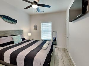 a bedroom with a large bed with a ceiling fan at Oasis On The Bay in Rockport