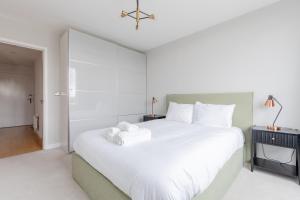 a bedroom with a large white bed and a desk at Chic Cosy & Well-Connected 1BD Flat Bermondsey! in London