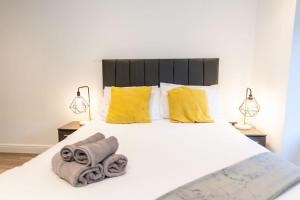 um quarto com uma cama branca e toalhas em One Bedroom Apartments in Liverpool City Centre em Liverpool