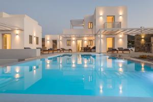 a villa with a swimming pool in front of a house at Beautiful Paros Villa - 1 Bedroom - The Calming Villa - Wonderful Sea Views and Jacuzzi - Naousa in Livadia