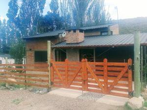 a house with a wooden fence in front of it at LC House in Potrerillos