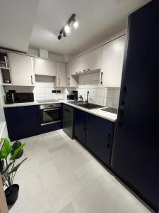 a kitchen with white cabinets and blue appliances at The Gallery - Bournemouth Town Centre - Beach 5 Minute Walk - Superfast WiFi - Outdoor Terrace - Sleeps 6 - Netflix - Contractor Friendly - Long Stay Rates - Coffee Machine in Bournemouth