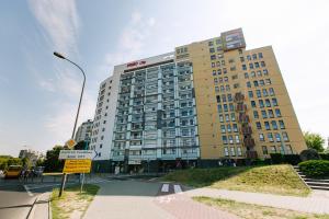 wysoki budynek z znakiem ulicznym przed nim w obiekcie RENTTNER Apartamenty w Warszawie