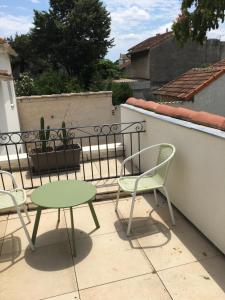 um pátio com uma mesa e cadeiras numa varanda em Maison trois chambres, près remparts, jardin, piscine em Avignon