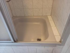 a bath tub in a bathroom with a tile floor at Monteurzimmer - Waldbronn in Waldbronn