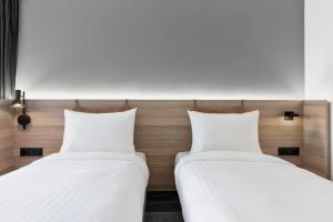 two beds sitting next to each other in a room at Moxy La Ciotat in La Ciotat