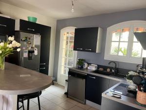 a kitchen with a refrigerator and a table in it at Maison proche Cannes /Grasse in Mouans-Sartoux