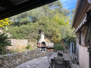 a outdoor patio with a stone wall and a brick oven at Maison proche Cannes /Grasse in Mouans-Sartoux