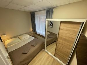- une petite chambre avec un lit et une fenêtre dans l'établissement Adria House, à Skwierzyna