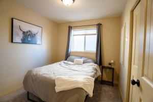 a small bedroom with a bed and a window at Cozy Countryside Crib in Grande Prairie