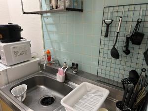 a kitchen with a sink and a microwave at Vintage III - Vacation STAY 14774 in Fukuoka