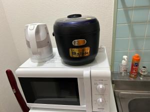 a slow cooker sitting on top of a microwave at Vintage III - Vacation STAY 14774 in Fukuoka