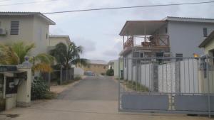 een lege straat met een hek voor een huis bij Stenen Koraal Piedra Dushi Resort in Willemstad