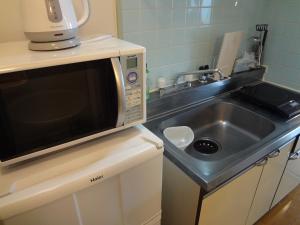 a kitchen with a microwave and a sink at Vintage III - Vacation STAY 14907 in Fukuoka
