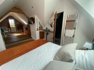 1 Schlafzimmer mit einem weißen Bett und einem Esszimmer in der Unterkunft La forge de Godincthun in Pernes-lès-Boulogne