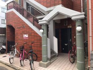 tres bicicletas estacionadas frente a un edificio en Vintage III - Vacation STAY 14907, en Fukuoka