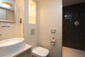 a white bathroom with a sink and a toilet at The King's Head Hotel Wetherspoon in Beccles