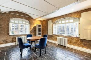 Habitación con mesa, sillas y ventanas. en Charming Home in St Katharine Docks, en Londres