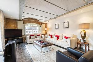 a living room with couches and a flat screen tv at Charming Home in St Katharine Docks in London