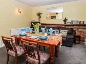 a dining room with a table and a couch at Millers Cottage in Malton