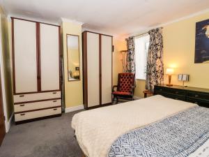 1 dormitorio con cama, escritorio y silla en Millers Cottage, en Malton
