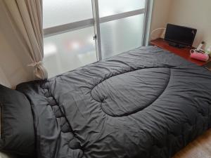 a bed in a room with a window and a laptop at Vintage III - Vacation STAY 14908 in Fukuoka