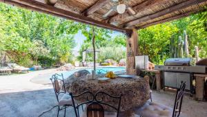 patio ze stołem i krzesłami oraz basenem w obiekcie Casa Marrojo Loja by Ruralidays w mieście Loja