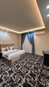 una camera da letto con un grande letto con tende blu di رواح للشقق المخدومة- الحوية a Al Muraysīyah