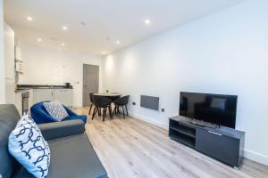 uma sala de estar com um sofá e uma televisão de ecrã plano em One Bedroom Apartments in Liverpool City Centre em Liverpool