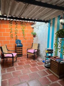 een patio met 2 stoelen en een bakstenen muur bij Beach Airport House in Cartagena