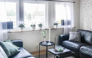 un soggiorno con 2 sedie in pelle e un tavolo di 3 Bedroom Cozy Home In Mönsterås a Mönsterås
