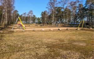 un parco vuoto con un parco giochi con altalene gialle di 3 Bedroom Cozy Home In Mönsterås a Mönsterås Altre 11 foto