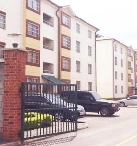 a building with cars parked in a parking lot at Homes by Val in Nairobi