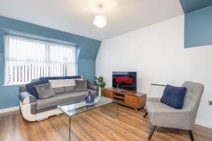 uma sala de estar com um sofá e uma televisão em 1BR Hideaway in Coventry - MH Apartment em Coventry
