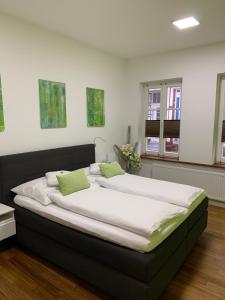 um quarto com uma cama grande e almofadas verdes em Ferienwohnung Janus Altstadt-Hameln Haus 2 inklusive Parkplatz - mit und ohne Terrasse oder Loggia em Hameln