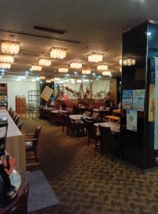 ein Esszimmer mit Tischen und Stühlen sowie ein Restaurant in der Unterkunft Okido Hotel in Tonosho