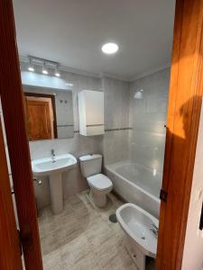 a bathroom with a sink and a toilet and a tub at Los Luceros de Esmeralda in Cala de Finestrat