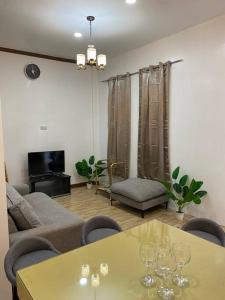 a living room with a table with wine glasses on it at Balai ni Atan - relaxing studio unit near airport in General Santos