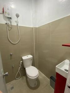 a bathroom with a toilet and a shower at Balai ni Atan - relaxing studio unit near airport in General Santos