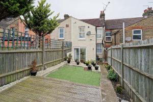 a backyard with a wooden fence and a yard with plants at Immaculate 3-Bed House in Chatham in Chatham