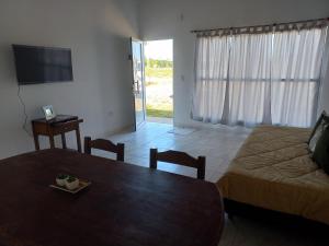 a living room with a bed and a table and a television at INGA in Ituzaingó