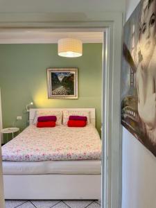 - une chambre avec un lit et 2 oreillers rouges dans l'établissement Bnbook Lago Maggiore Studio, à Castelletto sopra Ticino