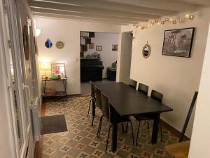 ein Esszimmer mit einem schwarzen Tisch und Stühlen in der Unterkunft Maison trois chambres, près remparts, jardin, piscine in Avignon